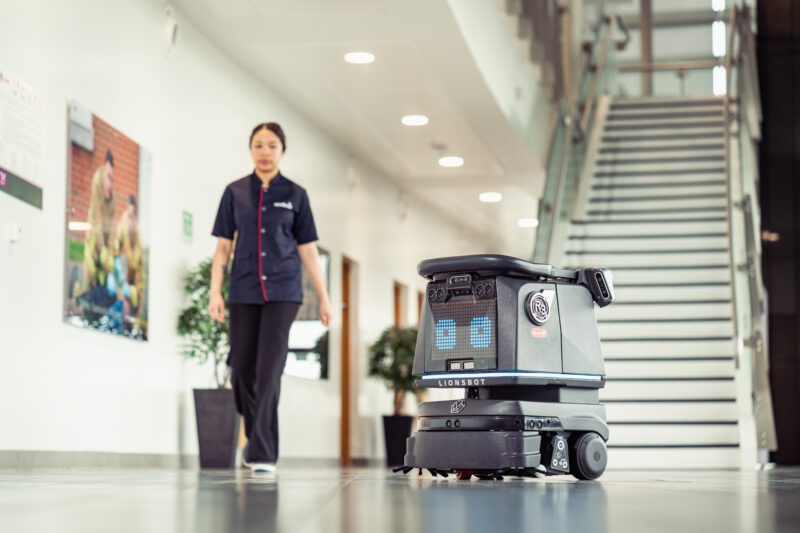 Facilities Management Photography for Sodexo at Scottish Fire and Rescue HQ, Glasgow 10 Lionsbot cleaning robot moving through a corridor with a Sodexo staff member walking behind it