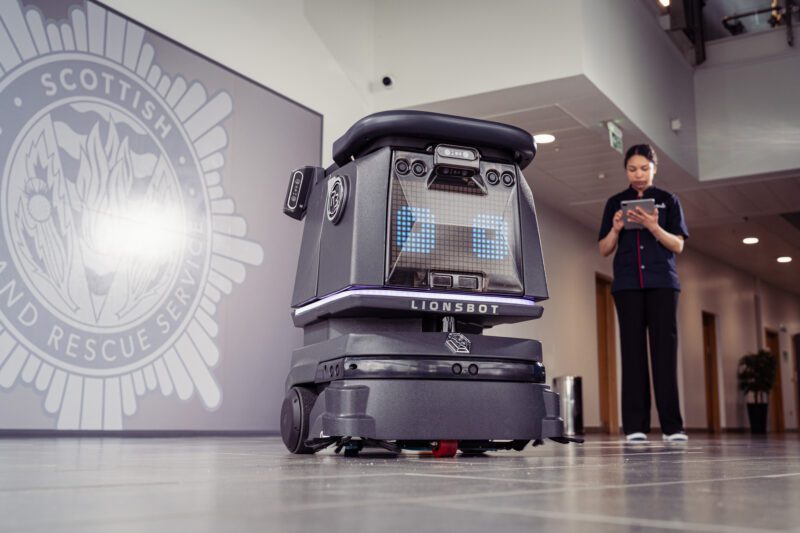 Facilities Management Photography for Sodexo at Scottish Fire and Rescue HQ, Glasgow 11 Close-up of a Lionsbot autonomous cleaning robot in a lobby, with a Sodexo staff member in the background