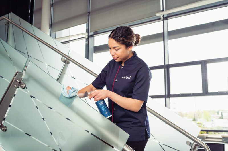 Facilities Management Photography for Sodexo at Scottish Fire and Rescue HQ, Glasgow 9 Sodexo cleaning staff member wiping down a glass staircase railing