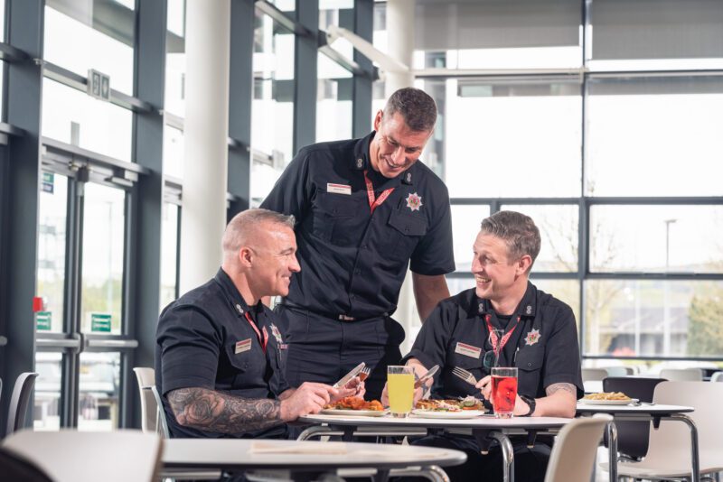 Facilities Management Photography for Sodexo at Scottish Fire and Rescue HQ, Glasgow 7 Three firefighters sharing a laugh over lunch at a canteen table