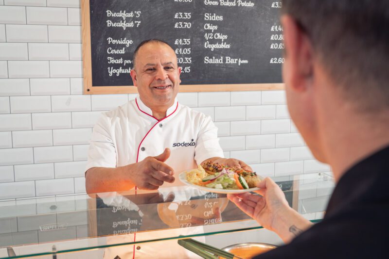 Facilities Management Photography for Sodexo at Scottish Fire and Rescue HQ, Glasgow 4 Sodexo chef in whites serving a plated meal to a customer at a canteen counter
