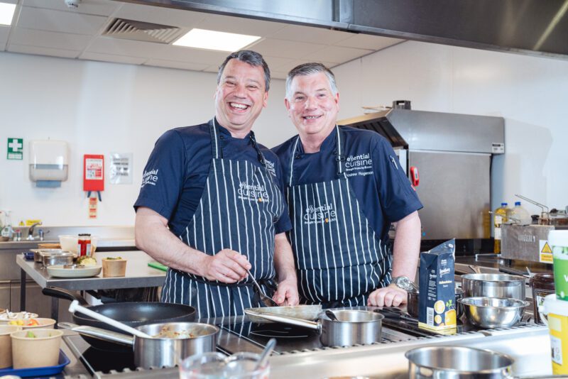 Essential Cuisine - behind the scenes 6 Two Essential Cuisine chefs preparing chicken and vegetables together in the development kitchen