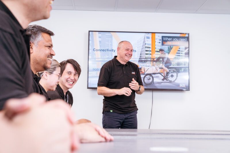 Photographing the invisible: inside SGS's new testing laboratory 9 SGS colleagues laughing together during a team presentation on connectivity services