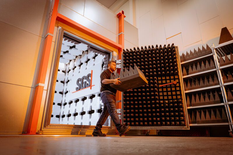 SGS technician carrying a foam absorber panel into a fully lined RF semi-anechoic test chamber