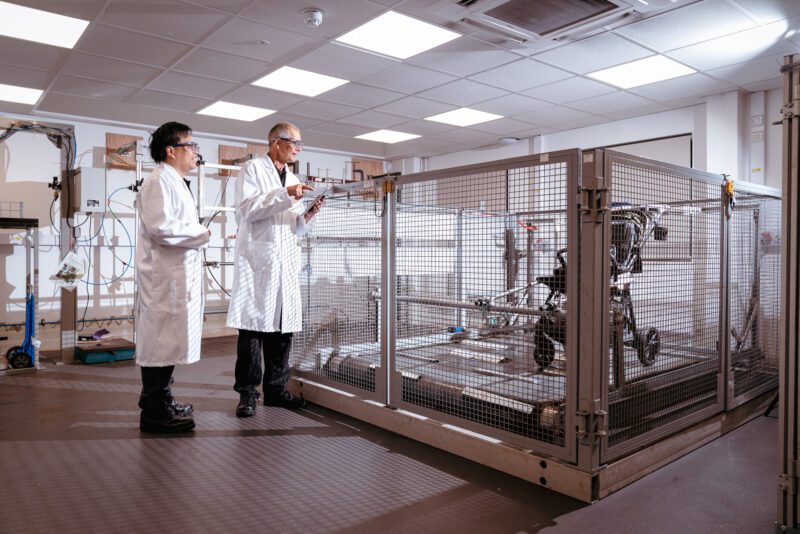Photographing the invisible: inside SGS's new testing laboratory 5 Two SGS technicians in lab coats and safety glasses monitoring a pushchair durability test